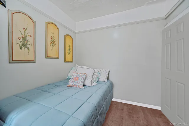 a bedroom with a bed and painting on the wall