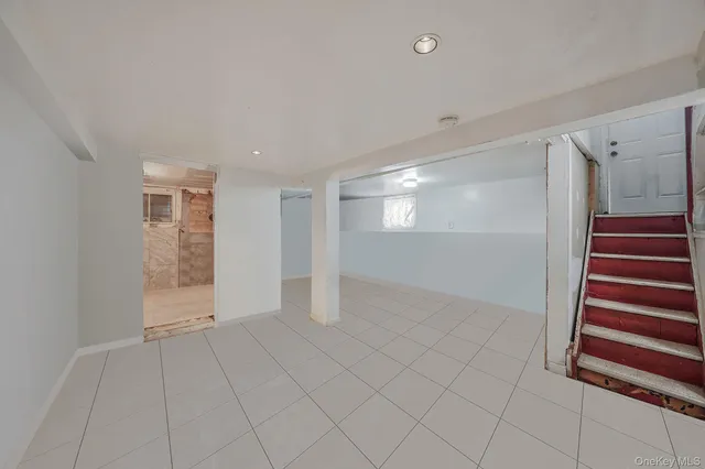 a view of an empty room with wooden floor and windows