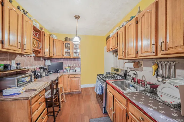 a kitchen with stainless steel appliances granite countertop a sink a stove and a wooden floors