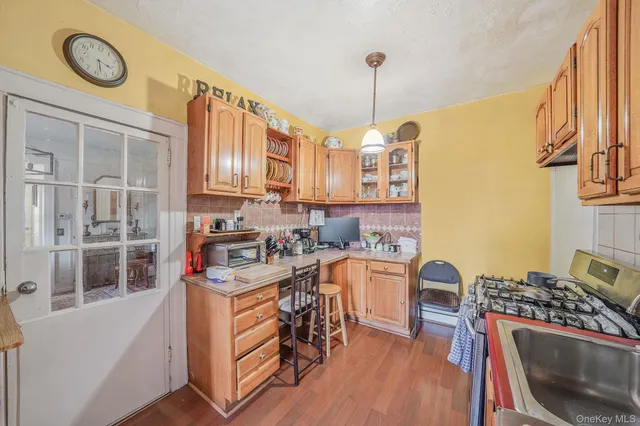 a kitchen with a stove a sink and a wooden floor