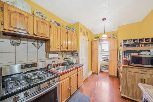 a kitchen with stainless steel appliances granite countertop a stove a sink dishwasher and cabinets with wooden floor