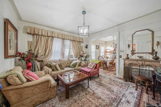 a living room with furniture a chandelier and a fireplace
