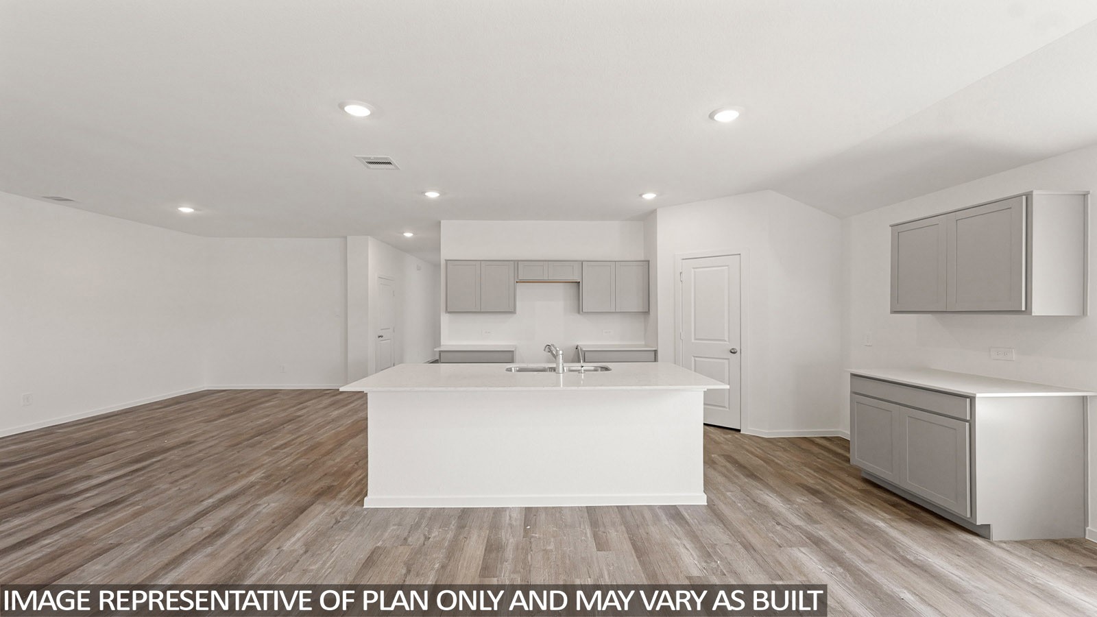 16819 Country Roots Avenue Conroe, TX 77302 - Photo 3 of 30 a view of a kitchen with kitchen island a sink wooden floor and a refrigerator
