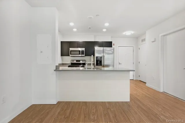 a kitchen with stainless steel appliances a refrigerator and a stove top oven