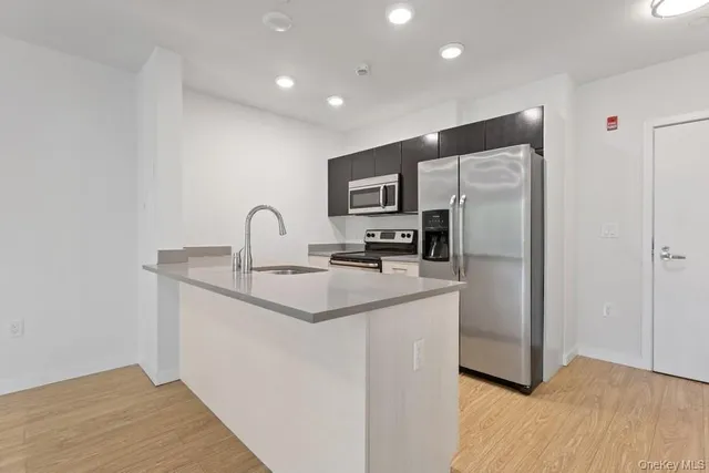 a kitchen with stainless steel appliances a sink and a refrigerator