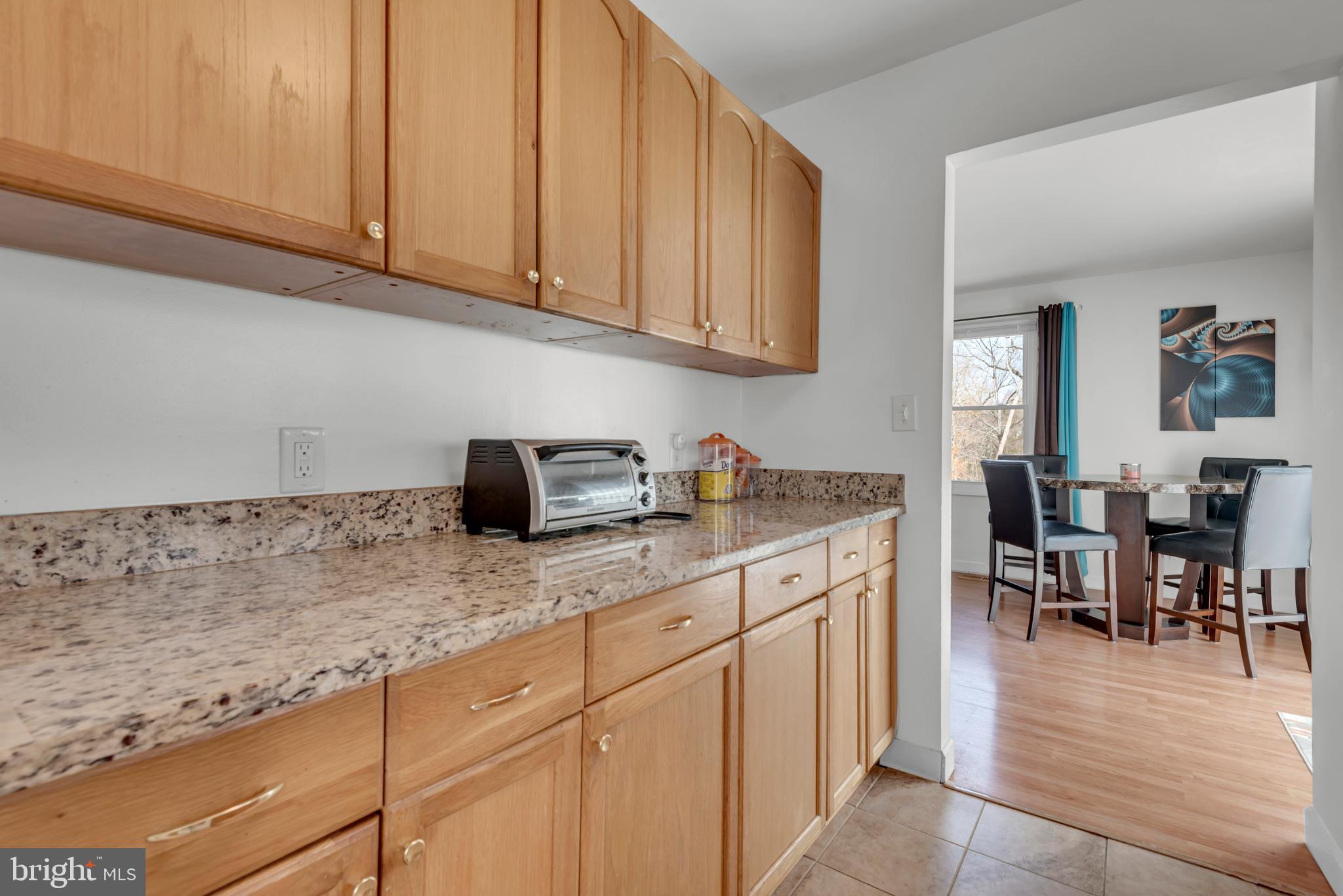2012 Frontier Court Fort Washington, MD 20744 - Photo 11 of 42 a kitchen with stainless steel appliances granite countertop a sink dishwasher a stove top oven a dining table and chairs with wooden floor