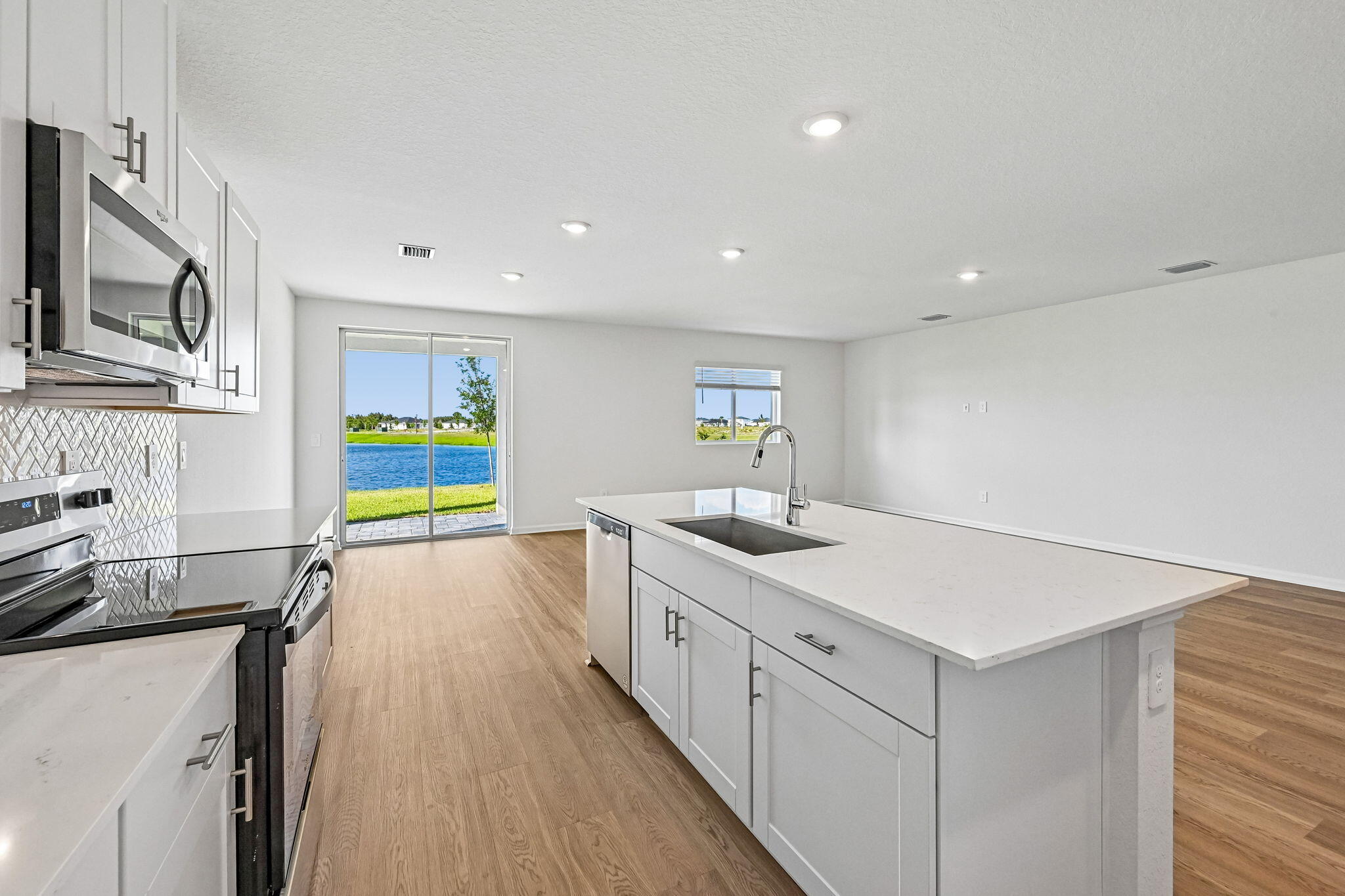 14503 Southwest New Dawn Road Indiantown, FL 34956 - Photo 13 of 42 a kitchen with stainless steel appliances granite countertop a sink and a stove top oven