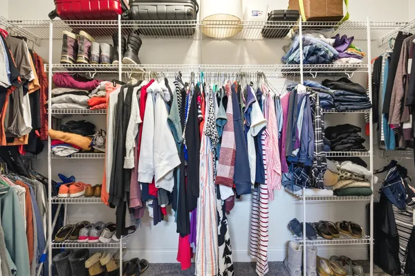 a view of walk in closet with clothes and shoes