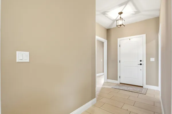 a view of a hallway with a chandelier fan