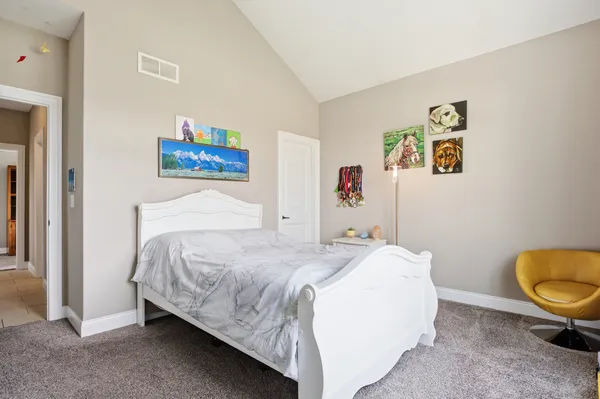 a bedroom with a bed and painting on the wall