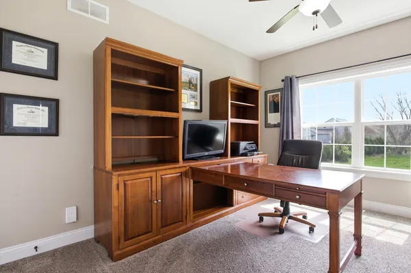 a view of a workspace with furniture and a window