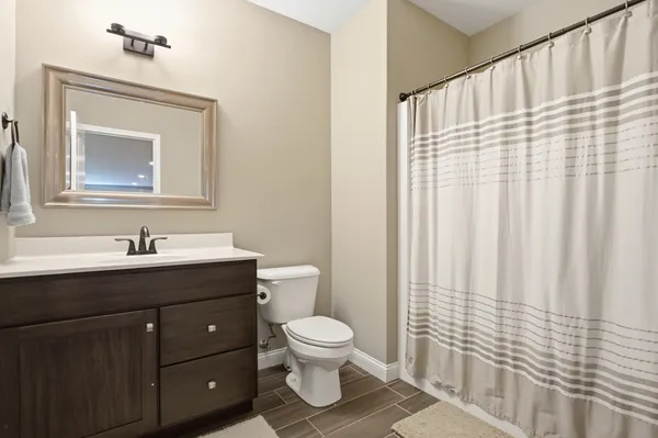a bathroom with a toilet a sink and a mirror