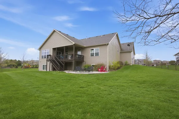 a view of a house with a yard and a large tree