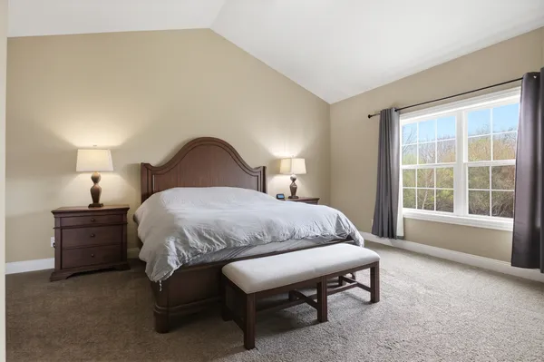 a bedroom with a bed lamp and a large window