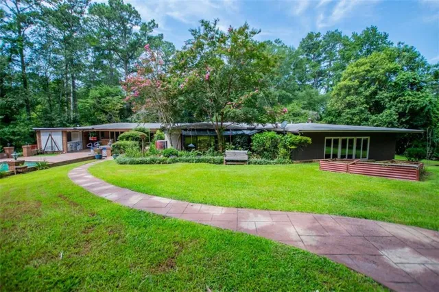 a view of house with swimming pool and a yard