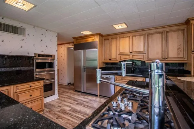a kitchen with stainless steel appliances a stove a sink and a refrigerator