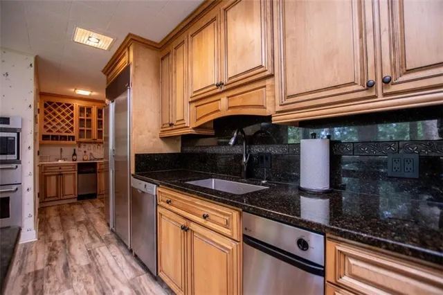 a kitchen with granite countertop a sink a stove and cabinets