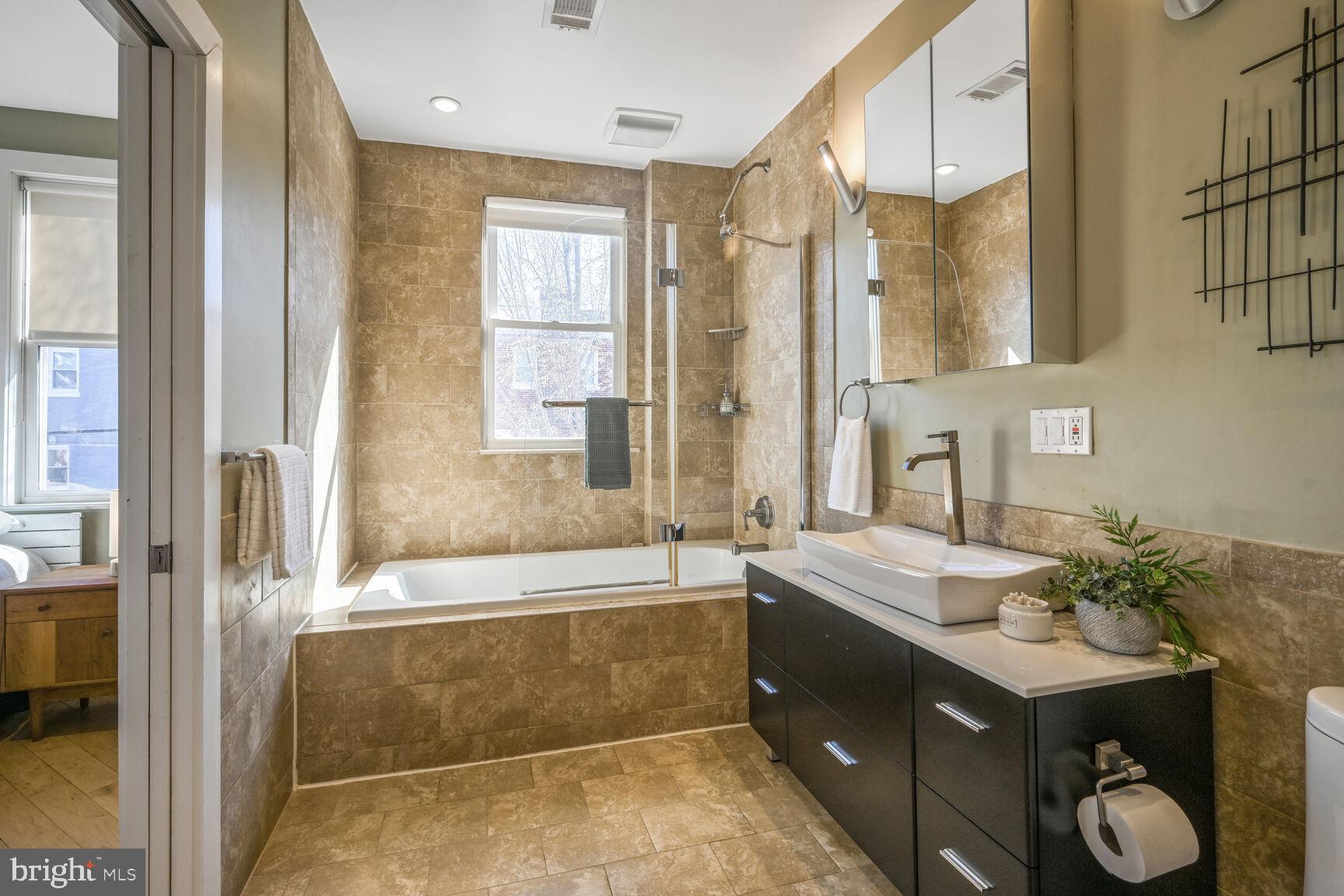 608 Rittenhouse Street Northwest Washington, DC 20011 - Photo 8 of 16 a bathroom with a sink mirror and a bathtub