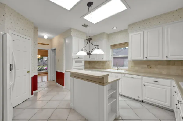 a kitchen with white cabinets and white appliances