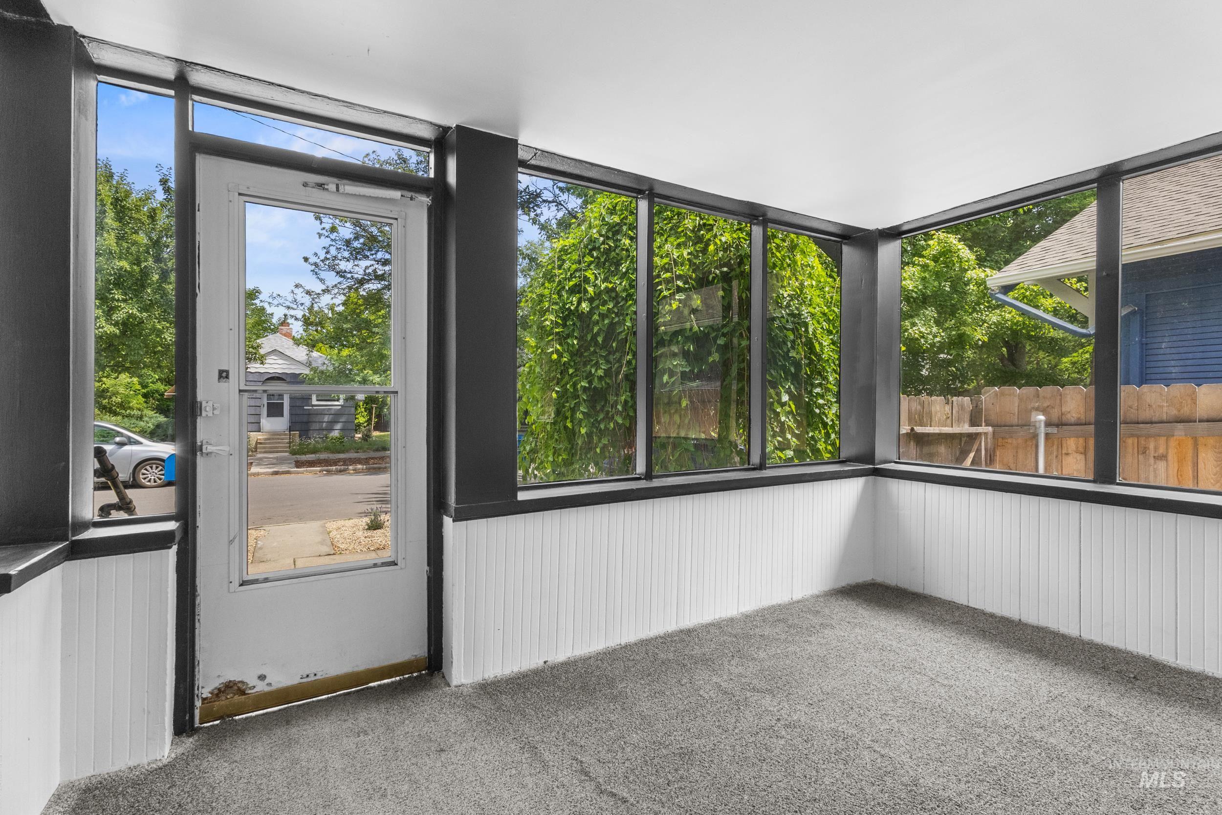 2119 West Brumback Street Boise, ID 83702 - Photo 5 of 30 Enclosed porch with a full-light entry door, multiple windows, beadboard wainscoting, and carpet flooring
