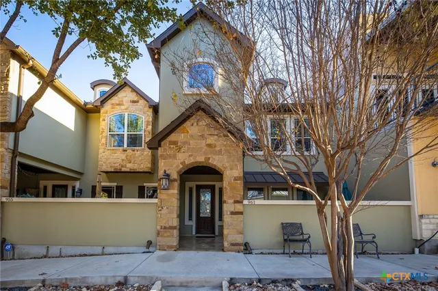 a front view of a house with a tree
