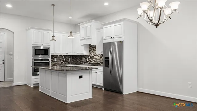 a kitchen with stainless steel appliances a white stove top oven and cabinets