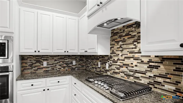 a kitchen with granite countertop a stove and a sink