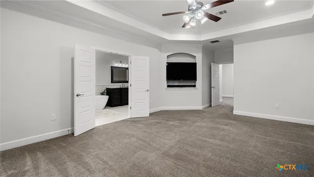 an empty room with closet and a ceiling fan