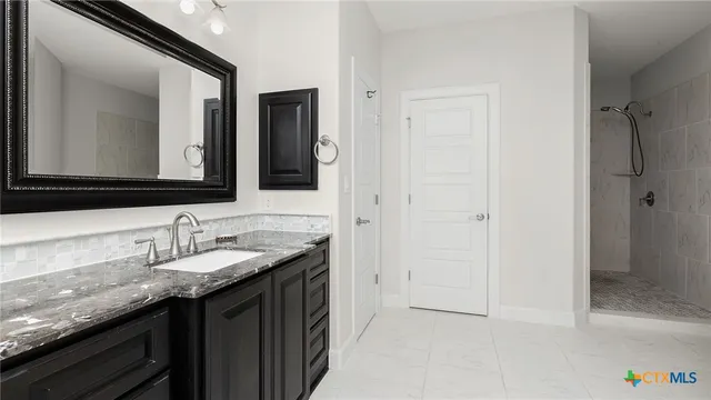 a bathroom with a granite countertop sink and a mirror