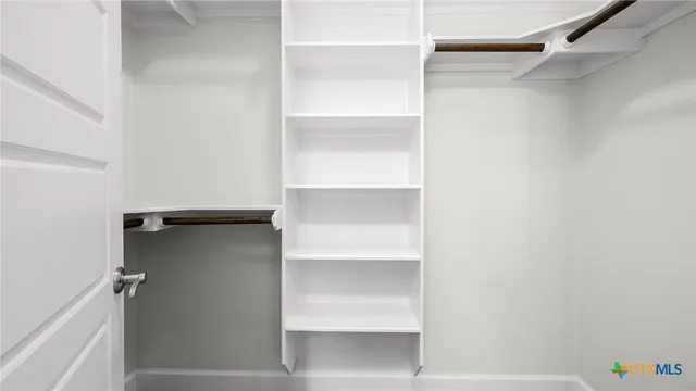 a view of walk in closet with empty racks