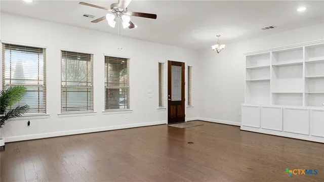 an empty room with cabinet and windows
