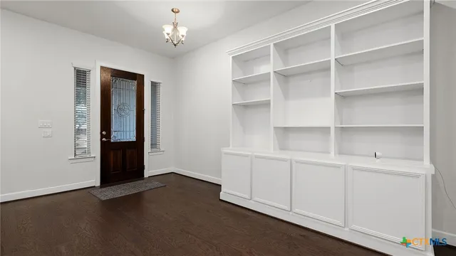 a view of an empty room with closet and a window