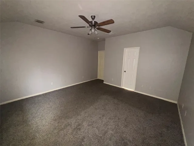 an empty room with a ceiling fan and a window