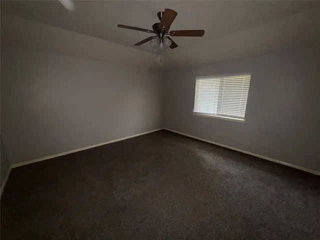 a view of a livingroom with a ceiling fan and window