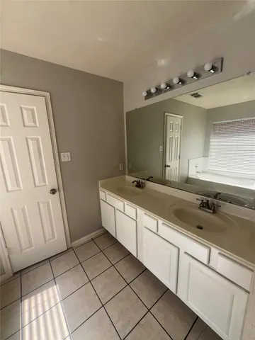 a large bathroom with a double vanity sink and a mirror