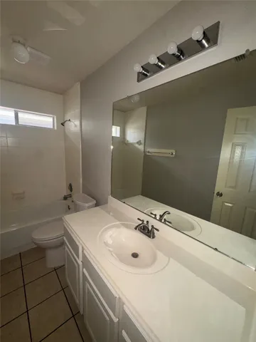 a bathroom with a sink and mirror with toilet