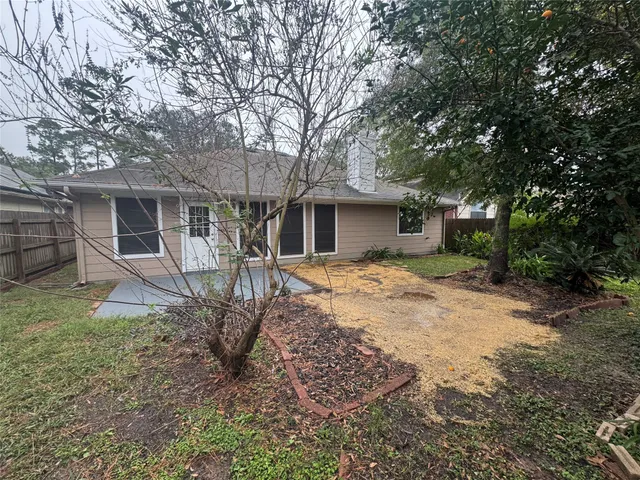 a view of a house with backyard and a tree