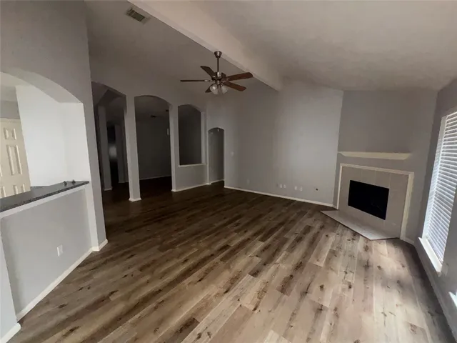a view of a livingroom with wooden floor and a ceiling fan