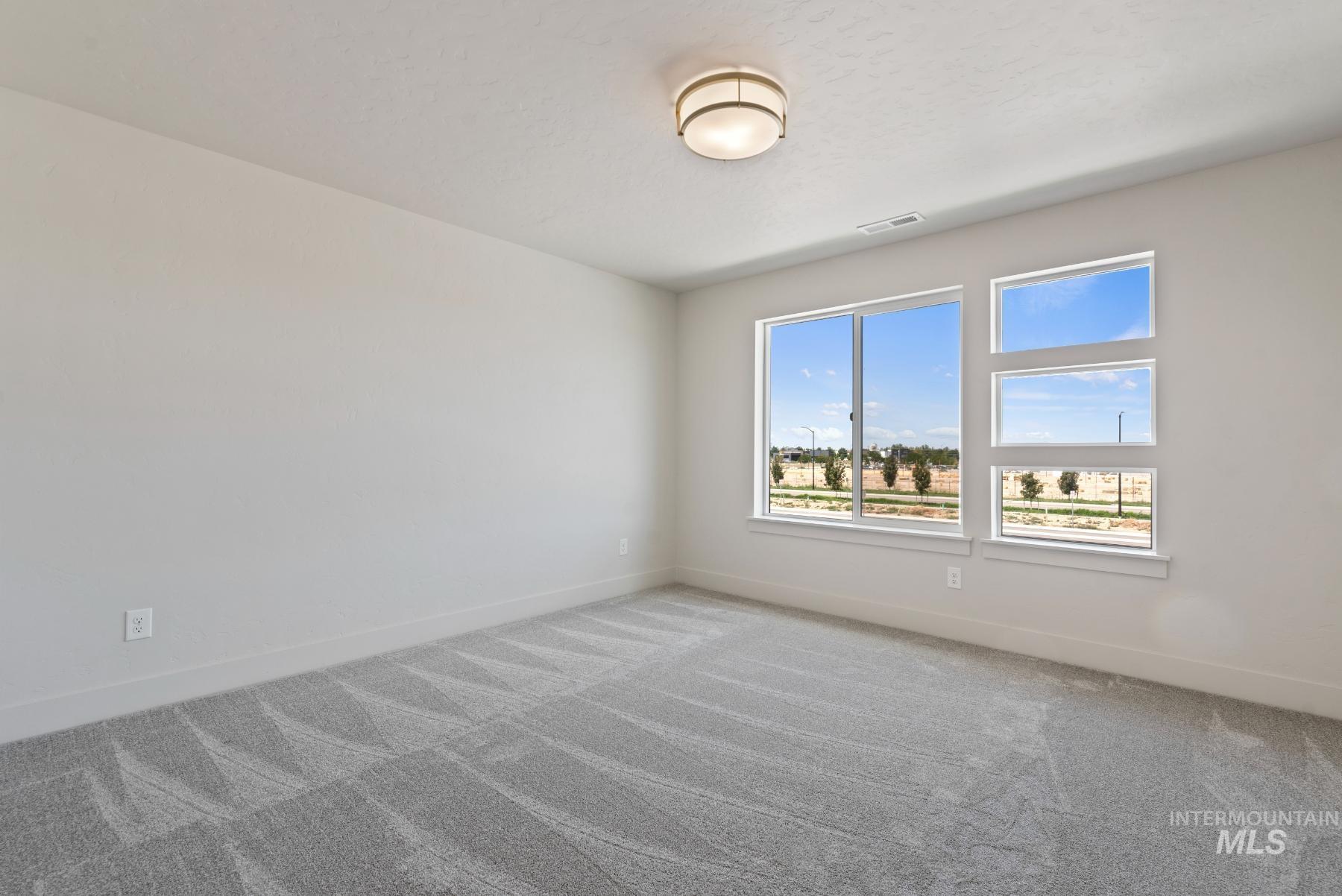 2866 North Stone Mill Avenue, Unit ROUGE Eagle, ID 83616 - Photo 10 of 18 Spare room featuring carpet flooring and baseboards