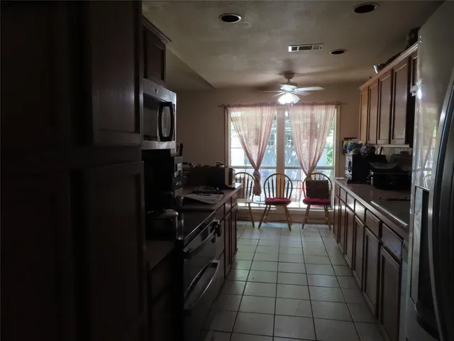 a kitchen with stainless steel appliances a sink stove top oven and cabinets
