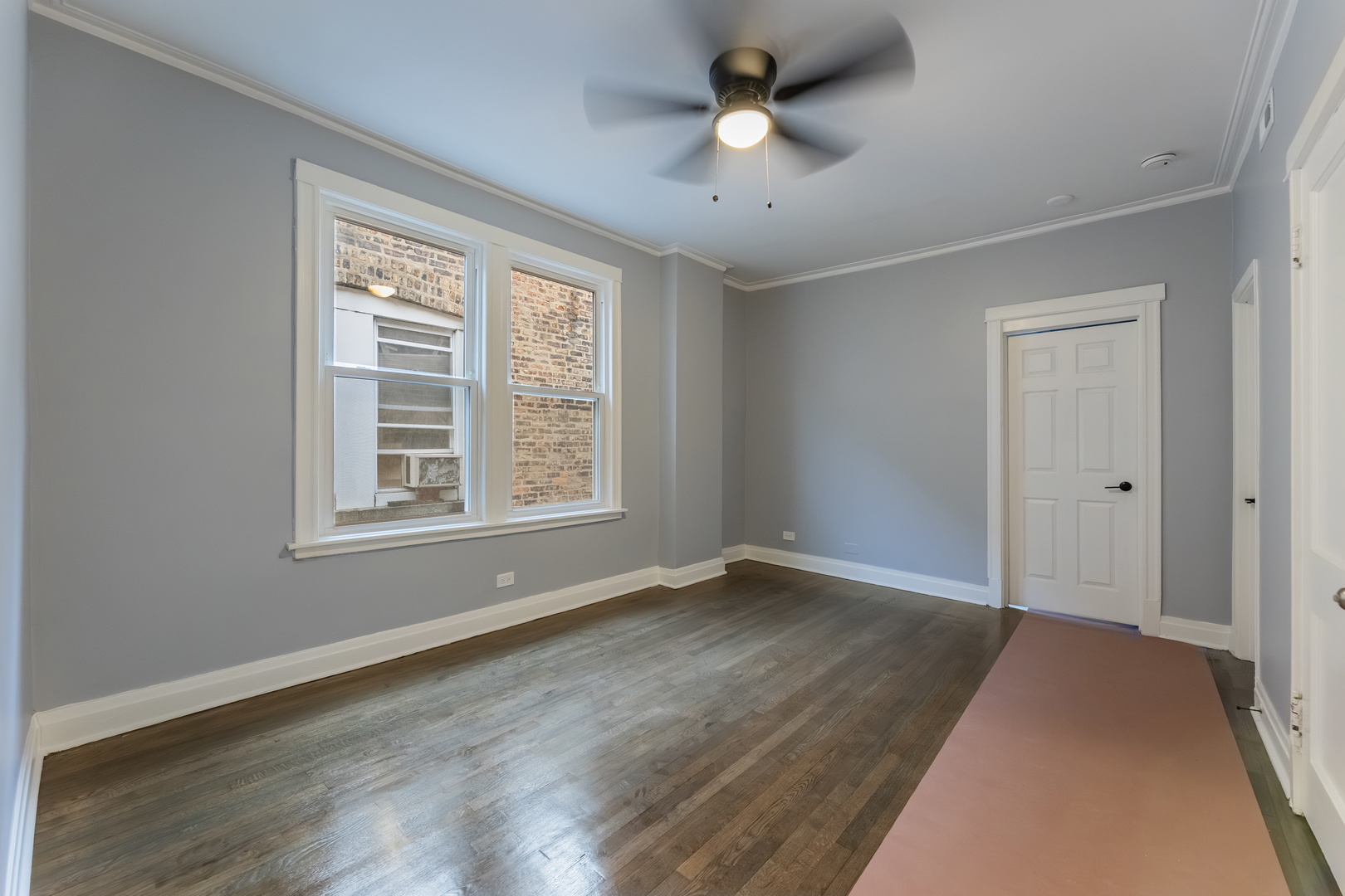 3821 West Fillmore Street, Unit 2B Chicago, IL 60624 - Photo 2 of 11 a view of an empty room with a window and wooden floor