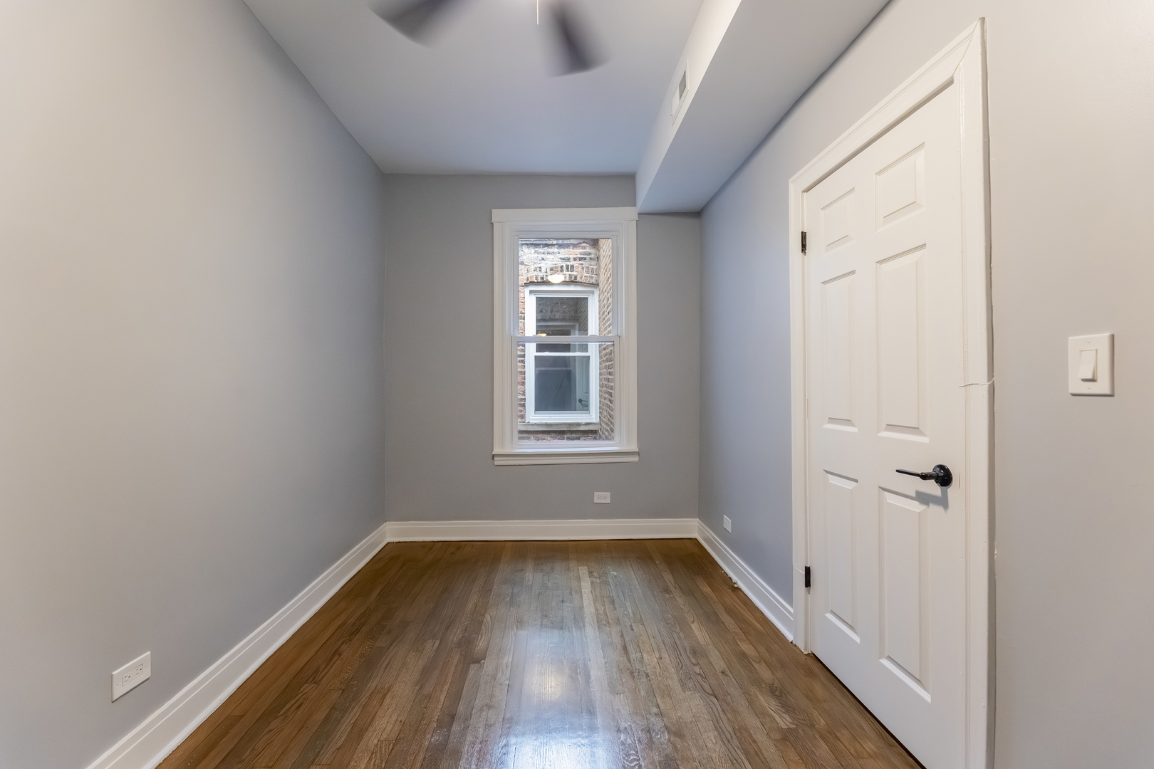 3821 West Fillmore Street, Unit 2B Chicago, IL 60624 - Photo 10 of 11 a view of a room with wooden floor and window