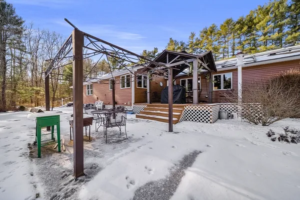 a view of a house with a snow on the road and fence