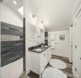 a bathroom with a granite countertop sink a toilet a mirror and shower