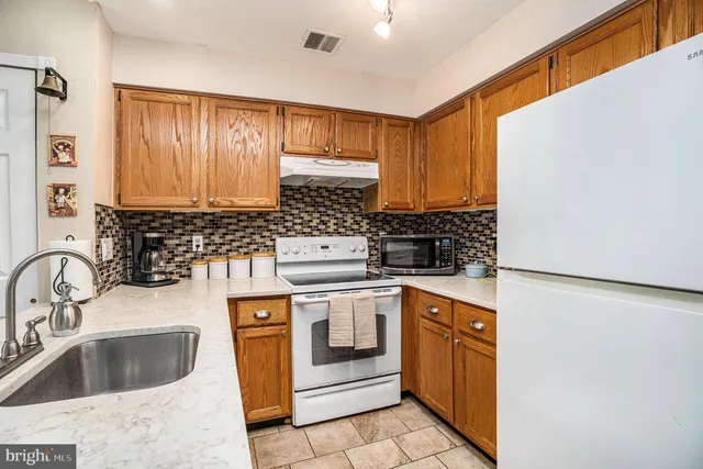 a kitchen with a stove sink and cabinets