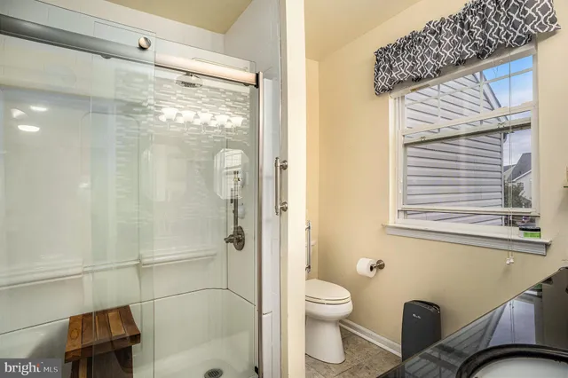 a bathroom with a shower a toilet and a sink