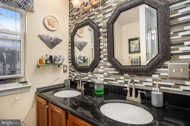 a bathroom with a granite countertop double vanity sinks and a mirror