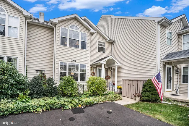 a view of a white house next to a yard