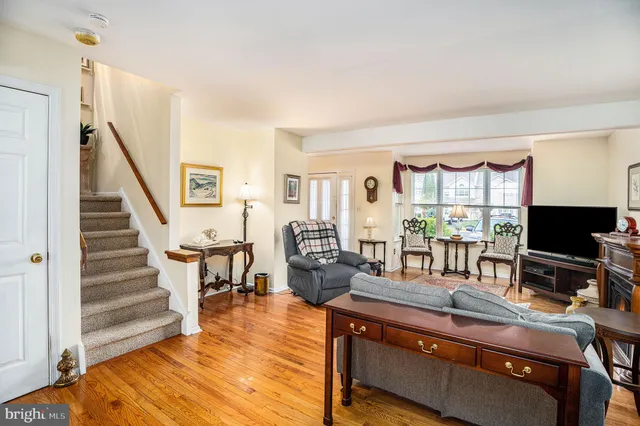 a living room with furniture a large window and wooden floor