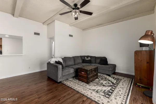 a living room with furniture and a wooden floor